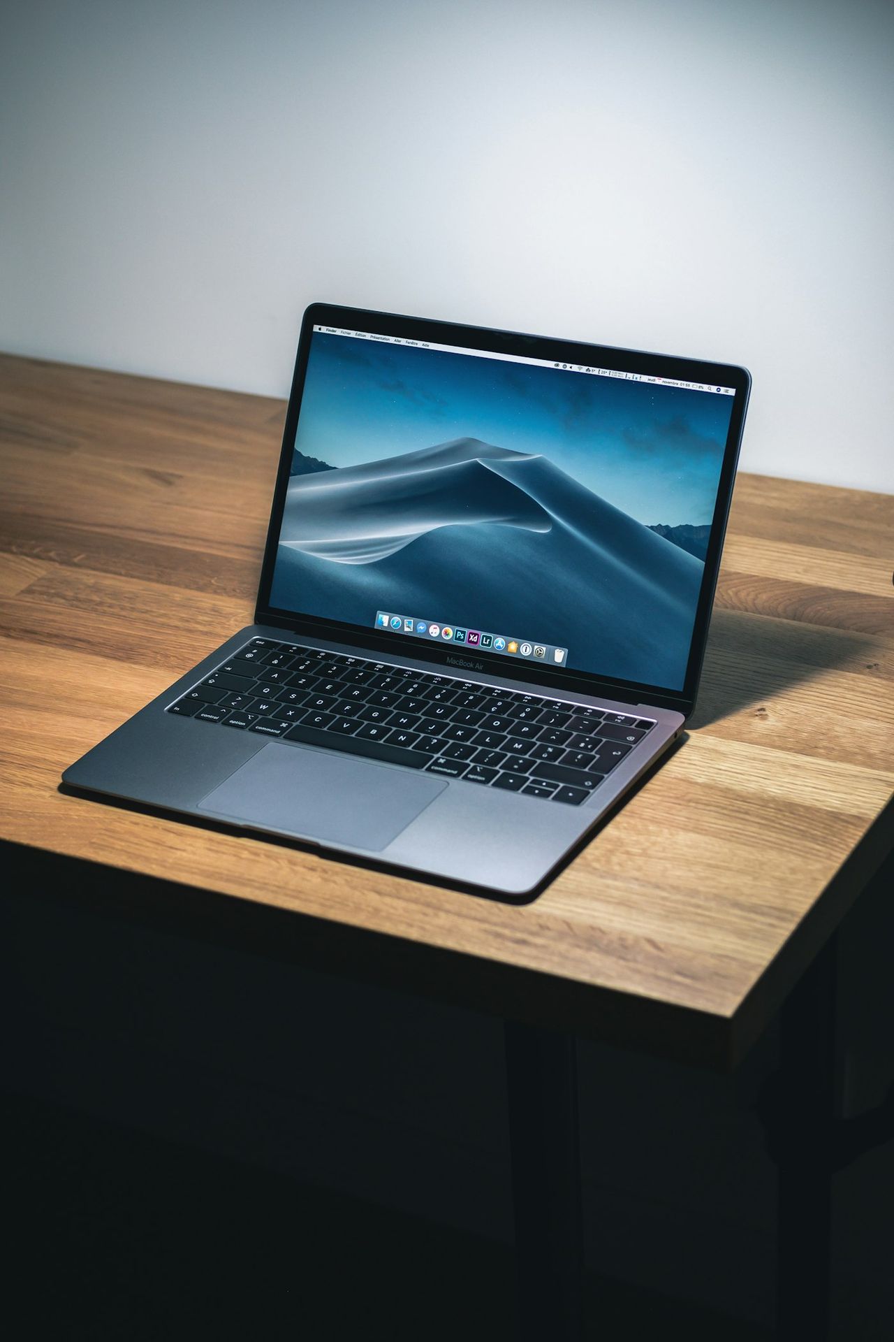 MacBook ouvert sur un bureau en bois